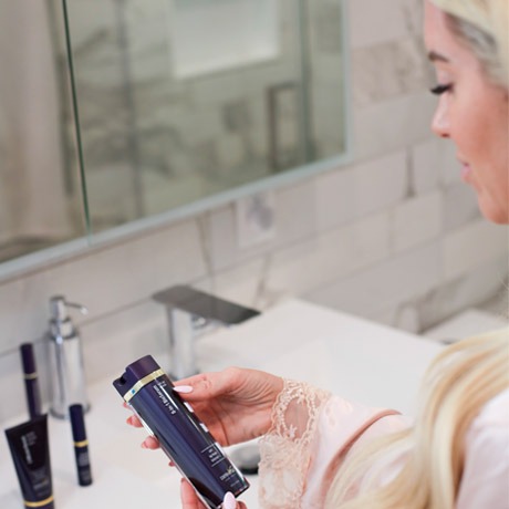 Applying the 8-in-1 BioSerum at the bathroom mirror